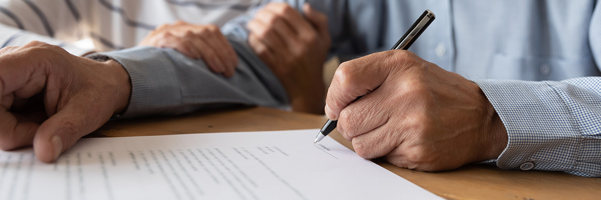 Enduring Power of Attorney - Close up picture of a couple reviewing and signing their Enduring Power of Attorney.